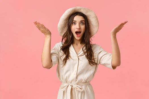 Fascinating news, congratulations. Amazed happy and ecstatic young feminine girlfriend in dress and hat, raising hands up sideways astonished and surprised of great thing happened, smiling.