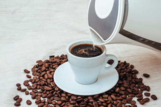 Cup of coffee and coffee beans on beige background