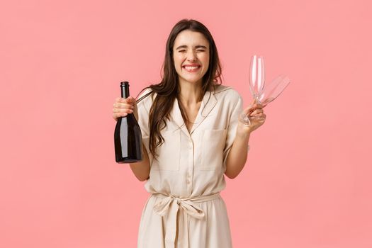 Happiness, celebration and congratulations concept. Charming and excited, ecstatic caucasian woman in dress, close eyes and smiling joyfully, eager open bottle champagne and drink together.