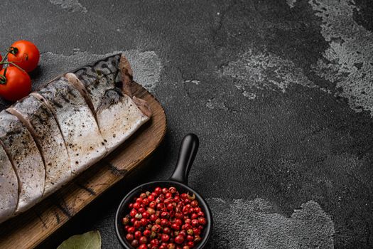 Marinated mackerel whole fish set, on black dark stone table background, with copy space for text