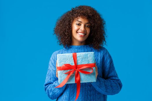 Holidays, winter season and christmas concept. Lovely cute african-american woman wrapped her present to give it boyfriend on valentines day, smiling cheerful, saying happy new year.