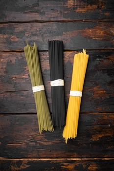 Multi colored pasta set, on old dark wooden table background, top view flat lay, with copy space for text