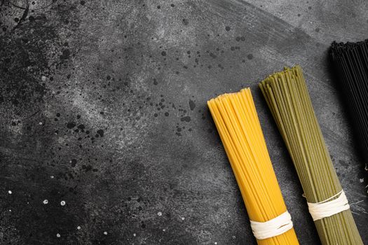 Multi colored pasta set, on black dark stone table background, top view flat lay, with copy space for text