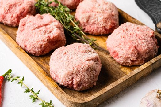 Raw minced meat made into meatballs set, on white stone table background