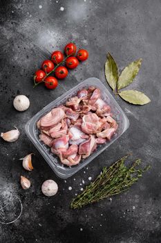 Raw chicken gizzards market plastic pack set, on black dark stone table background, top view flat lay