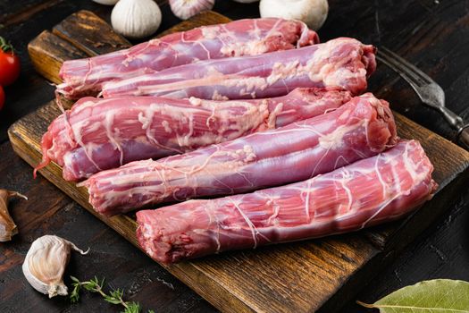 Raw turkey neck without skin set, on old dark wooden table background