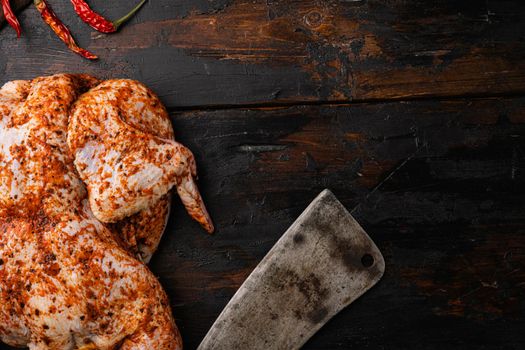 Raw chicken tabaka ready for cooking with ingredients set, on old dark wooden table background, top view flat lay, with copy space for text
