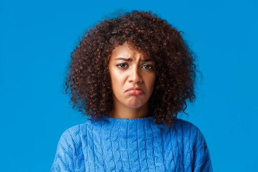 Depression, sadness and emotions concept. Close-up uneasy and sad cute african-american sulking girl feeling upset, pulling grimace and frowning, want cry, standing distressed over blue background.