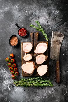 Raw beef marrow bones set, on black dark stone table background, top view flat lay