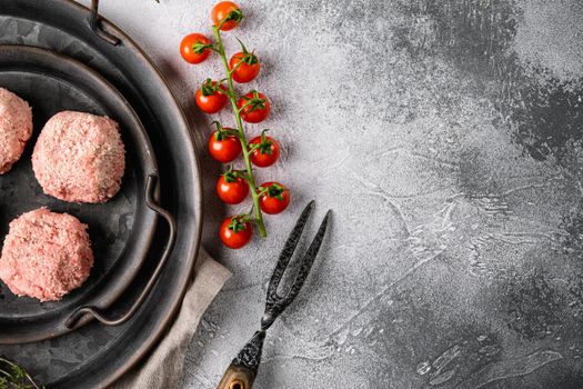 Raw ground beef meat steak cutlets set, on gray stone table background, top view flat lay, with copy space for text