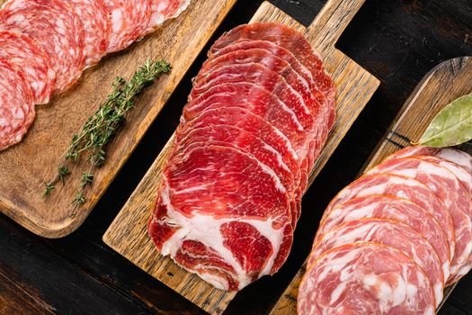 Cold smoked meat slices prosciutto set, on old dark wooden table background, top view flat lay