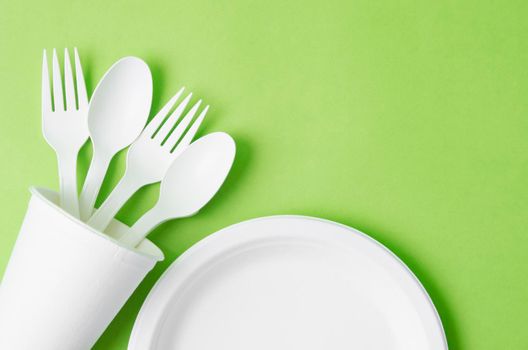 Eco friendly biodegradable paper disposable for packaging food and paper glass on green background.