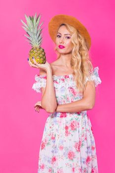 Portrait of funny woman and pineapple over pink background. Summer, diet and healthy lifestyle concept.