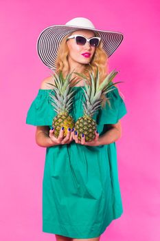 Portrait of funny woman and pineapple over pink background. Summer, diet and healthy lifestyle concept.