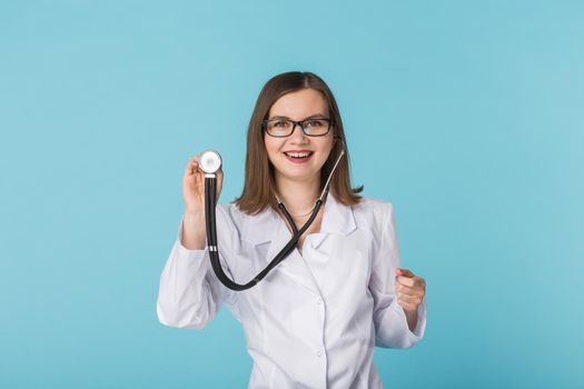 Doctor with stethoscope over blue background with copy space.