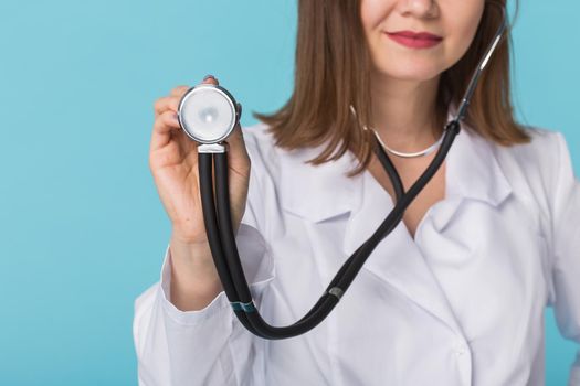 Doctor with stethoscope, close up over blue background.