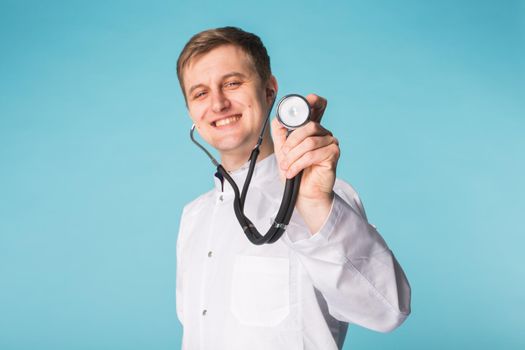 Doctor with stethoscope, close up over blue background.
