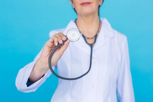 Doctor with stethoscope, close up over blue background.