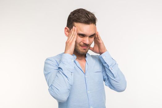 Portrait of a young handsome thinking man and feels a headache on white background.