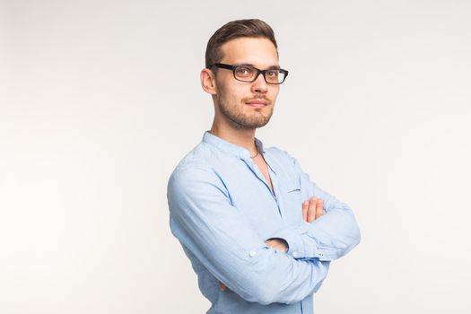 Business and people concept - Handsome man in black glasses over white background, arms crossed.