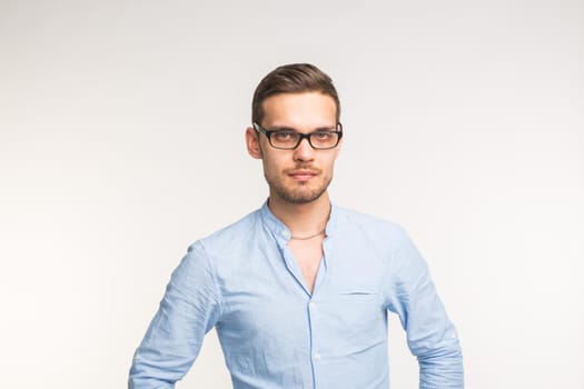 Handsome confident serious man in glasses standing on white background.