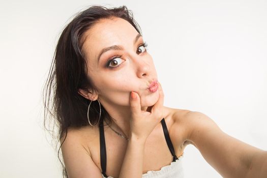 Photography and people concept- Close up beautiful woman making selfie photo with funny face.