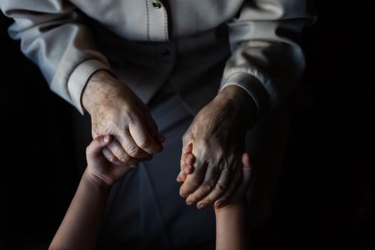 Little baby girl and very old woman. Little child hugging grandmother. Granddaughter