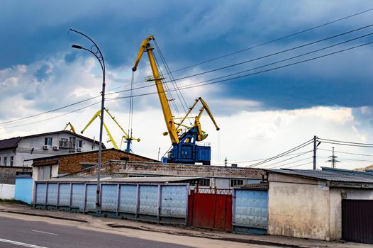 Port cargo crane for loading and unloading ships. Cargo crane. Port lifting equipment. Moving cargo. Industrial Zone. Water ship transportation. Transport business.