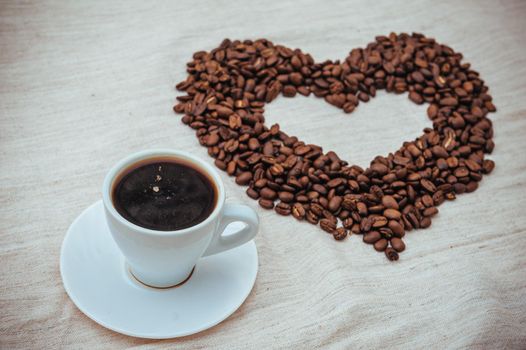 Cup of Coffe. Coffee beans in shape of heart. coffee beans isolated on white background. roasted coffee beans, can be used as a background.