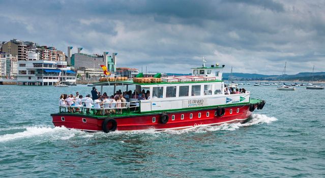 View from the sea of a passenger ferry in the bay of Santander, in summer and with cloudy skies.