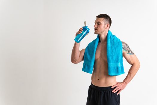 Male drink-water fitness is pumped with a towel on a white background isolated strong muscular lifestyle, water man person, muscles cardio. Towel copy pace, thirsty one muscle