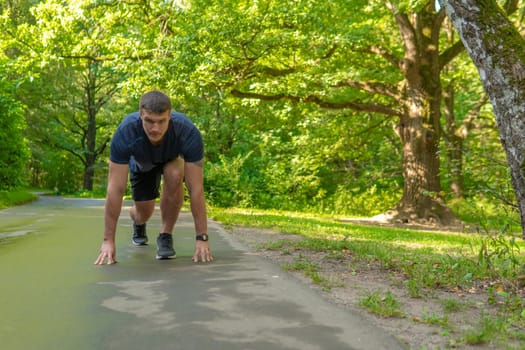 A man athlete runs in the park outdoors, around the forest, oak trees green grass young enduring athletic athlete active athlete workout outdoor fit recreation male, trees leisure cross, distance stretches