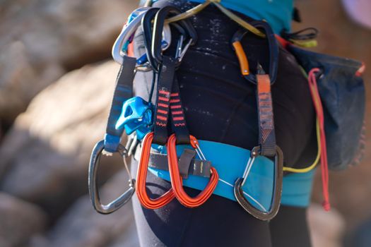 A man with climbing equipment, with easy-clipping carabiners and quick draws, hiker stands against the background of mountains and rocks, is engaged in extreme sports and rock climbing.