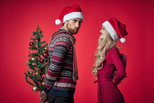 emotional man and woman gifts christmas new year red background. High quality photo