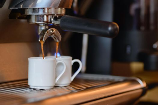 wo espressos are being freshly prepared on a professional machine