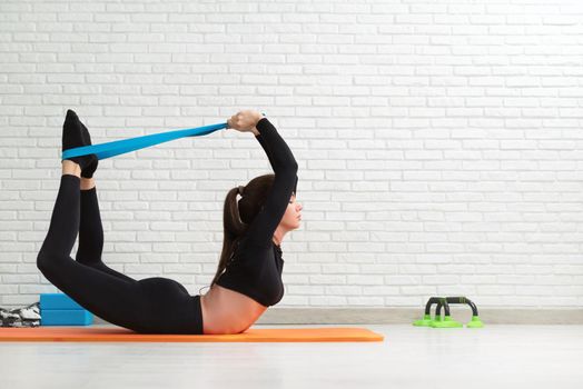 girl conducts a home workout stretching to strengthen her back