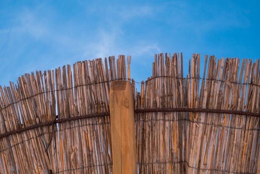 Part of the straw beach umbrellas and View of the beautiful blue sky with little clouds