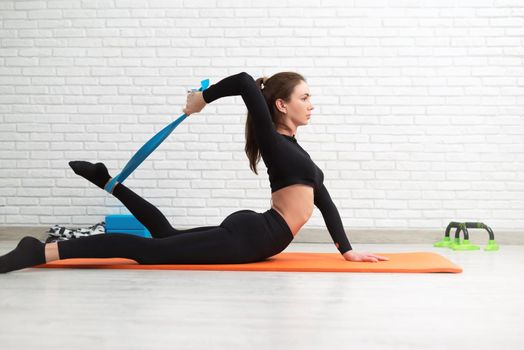 girl conducts a home workout stretching to strengthen her back