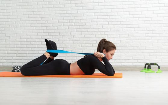 girl conducts a home workout stretching to strengthen her back