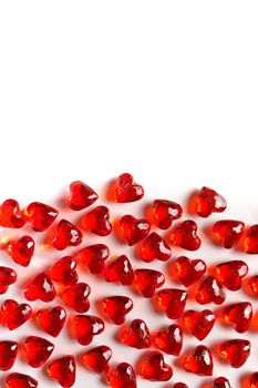 Directly Above Studio Full Frame Image of Sparkling Red Faux Gemstone Hearts on a White Studio Background. Gemstone Hearts are clustered on the Bottom of Frame with White Copy Space on the Top