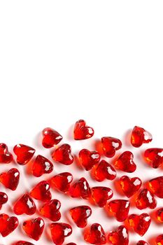 Directly Above Studio Full Frame Image of Sparkling Red Faux Gemstone Hearts on a White Studio Background. Gemstone Hearts are clustered on the Bottom of Frame with White Copy Space on the Top