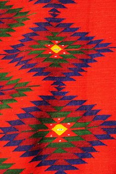 fragment of a red textile rug with Bulgarian ornament close-up