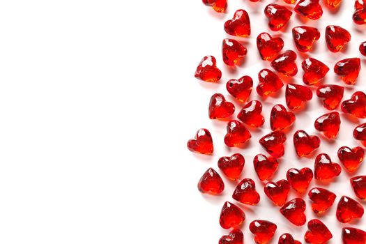 Directly Above Studio Full Frame Image of Sparkling Red Faux Gemstone Hearts on a White Studio Background. Gemstone Hearts are clustered on the Right with White Copy Space on the Left