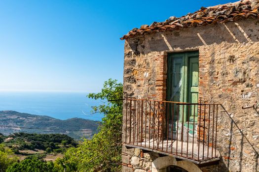 Balcony of an old house with view on the mediterranean sea in a sunny day, Sicily, Italy