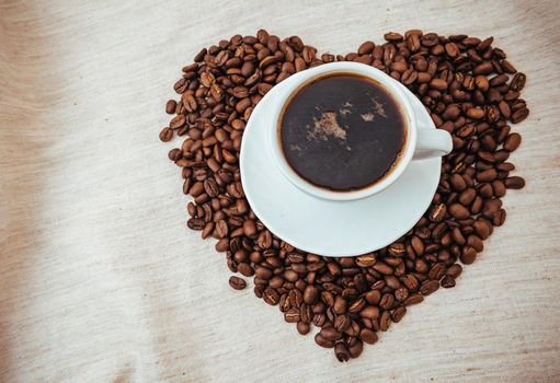 Cup of Coffe. Coffee beans in shape of heart. coffee beans isolated on white background. roasted coffee beans, can be used as a background.