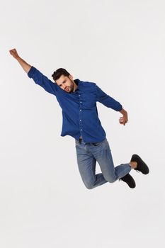 An attractive athletic businessman jumping up against white background.