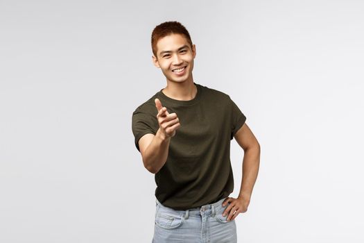 Nice work, good job. Portrait of young cheerful asian man pointing finger at camera and smiling satisfied, congratulate person with win, praise great choice, peeking or rectuiting for job.