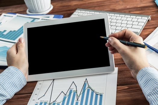 close-up, female hands with tablet. Business woman working at the table in the office