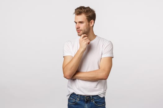 Thoughtful and creative good-looking male manager, designer decide what do, look away thinking, smiling pleased, have interesting idea, concept, standing white background dreamy.