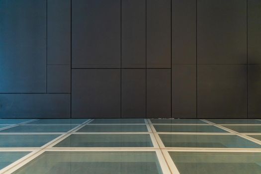 Glassy floor with big gray tiles on wall